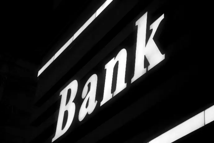 a bank sign lit up in the dark